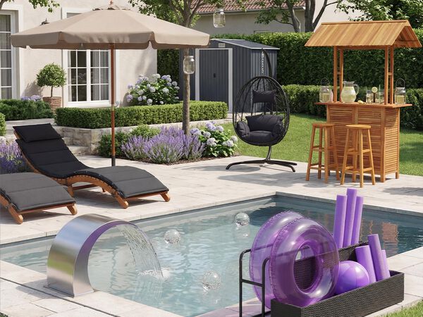Een modern terras met een gevoerde fauteuil onder een beige parasol, een hangstoel en een houten tuinbar met krukken, omringd door een verzorgde tuin, paarse bloemen en een kleine schuur op de achtergrond.