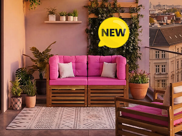 Nieuwe modulaire balkonsofaset met opvallende roze kussens en massief houten frame, gestileerd op een stadsbalkon met planten en een glazen balustrade, NEW-badge zichtbaar