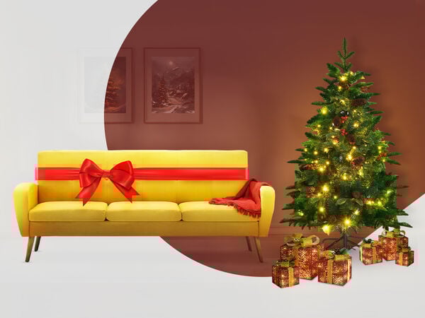 Een feestelijke scène met een felgele bank die is vastgebonden met een grote rode strik, alsof het een cadeau is. Rechts staat een versierde kerstboom die schittert met lichtjes, en verschillende ingepakte cadeaus liggen aan de voet. De achtergrond is warmbruin met twee ingelijste schilderijen aan de muur, en de hele scène is gedeeltelijk overlapt door een gebogen wit gedeelte aan de linkerkant, wat een moderne, gestileerde uitstraling geeft.
