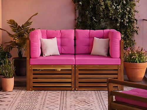 Nieuwe modulaire balkonsofaset met opvallende roze kussens en massief houten frame, gestileerd op een stadsbalkon met planten en een glazen balustrade, NEW-badge zichtbaar