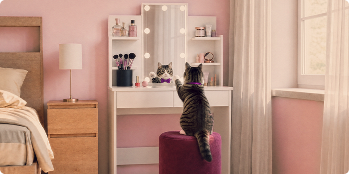 Kat die aan een kaptafel zit met opbergplanken in een roze slaapkamer.